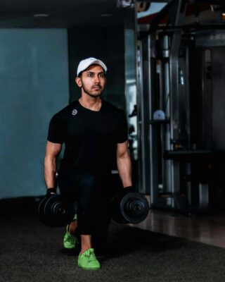 man holding black dumbbells